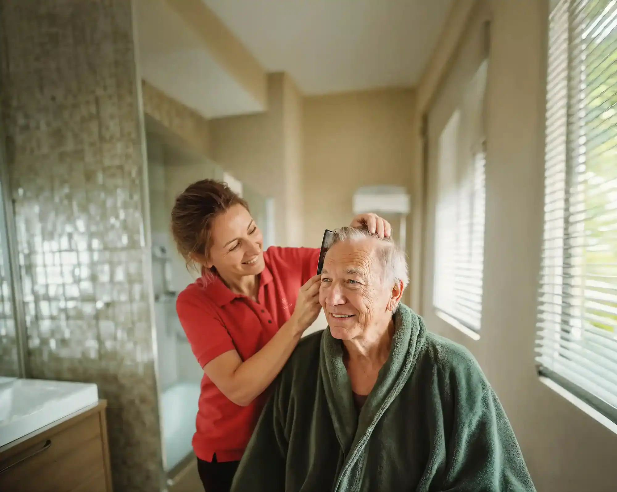 Caregiver helping elderly man with hair grooming as part of personal care at home