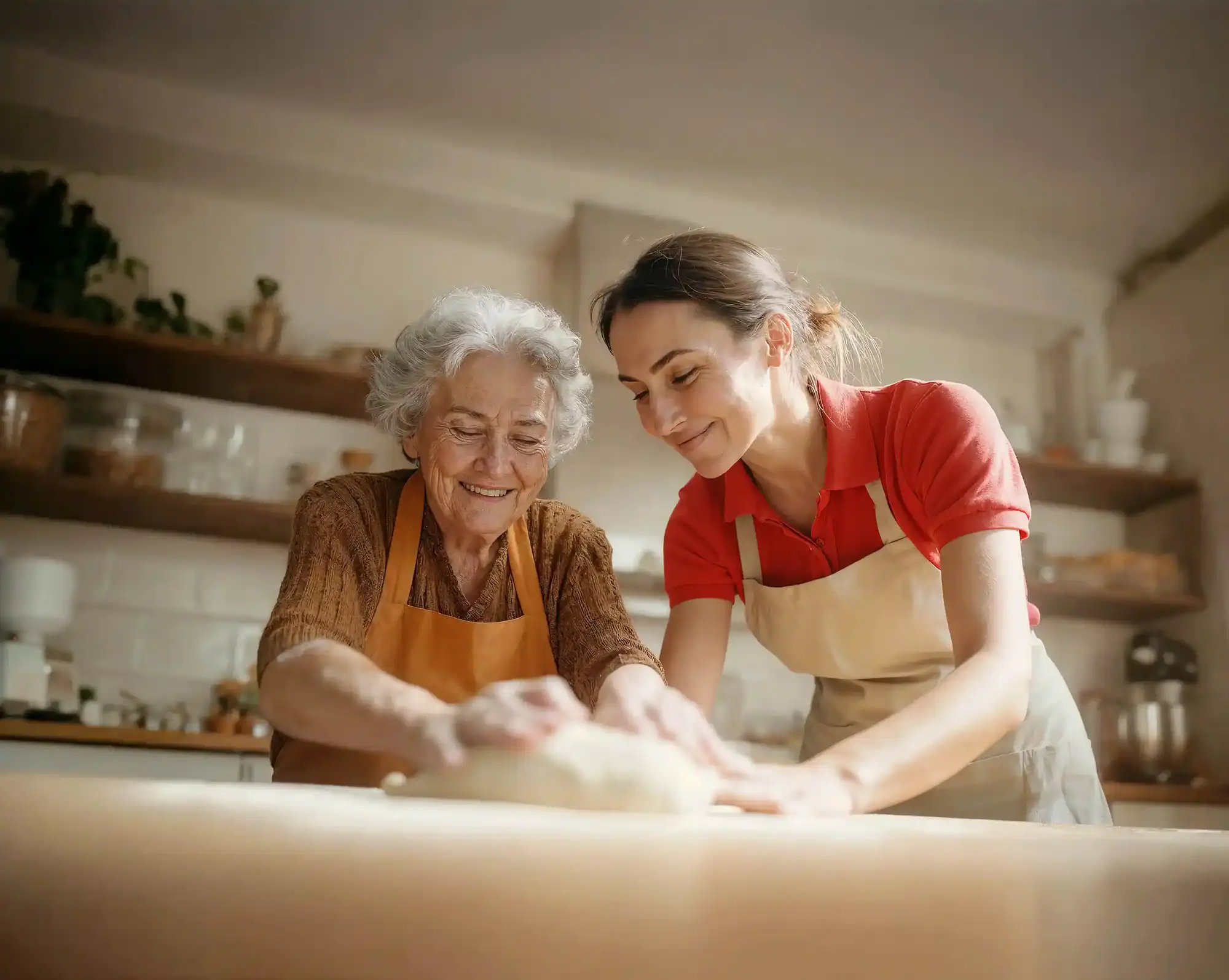 Caregiver and elderly woman cooking together in a home kitchen
